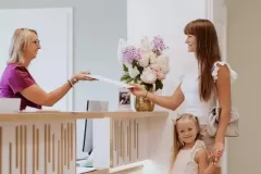 Mama z córeczką rozmawiają z Panią recepcjonistką